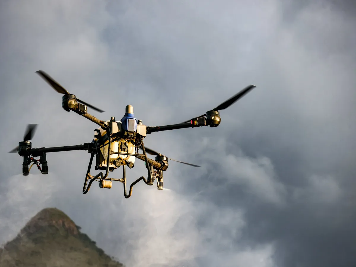 Multirotor drone in flight against a cloudy sky
